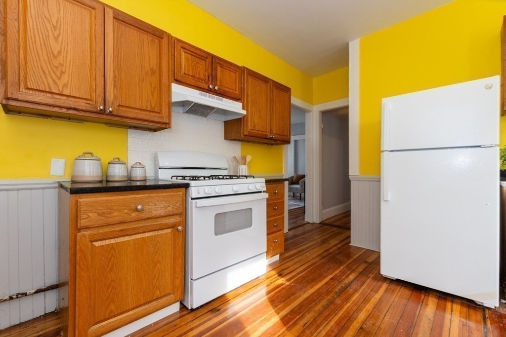 29 Mt Ida Road Boston, MA 02122 - Photo 11 of 22 a kitchen with a refrigerator a stove and wooden floor