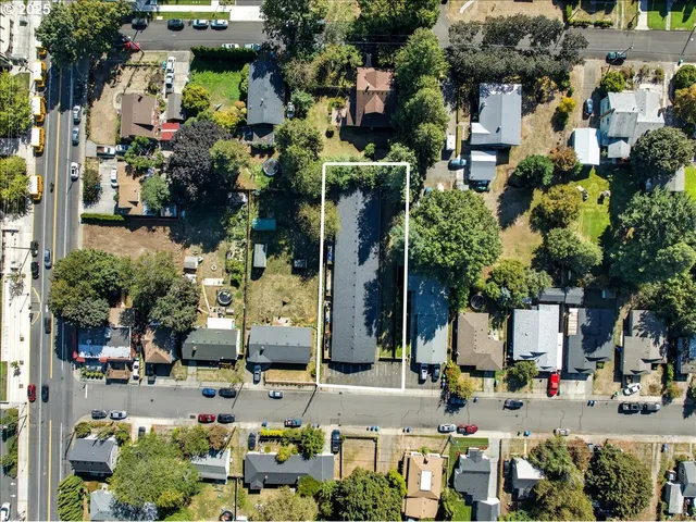 an aerial view of residential houses with outdoor space and parking