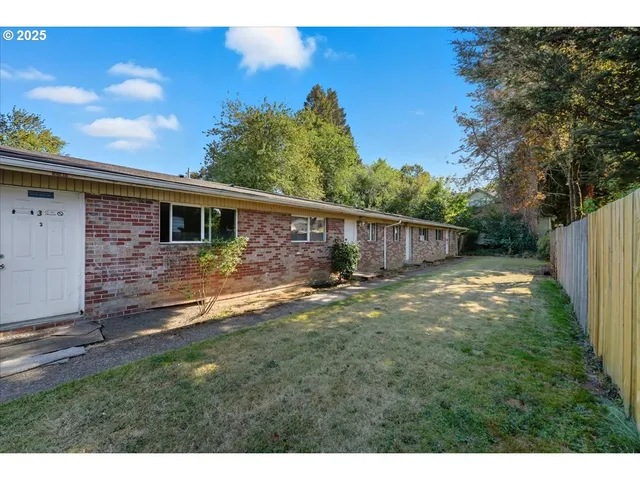 a backyard of a house with table and chairs