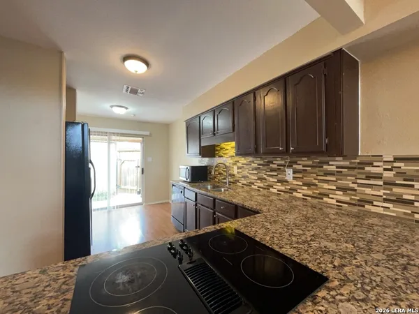 a kitchen with sink stove and refrigerator