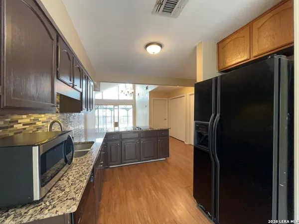 a kitchen with stainless steel appliances granite countertop a refrigerator and a stove