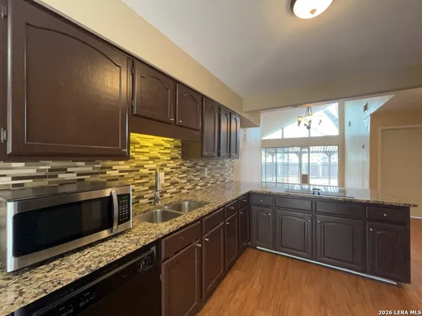 a kitchen with stainless steel appliances granite countertop a sink stove and cabinets