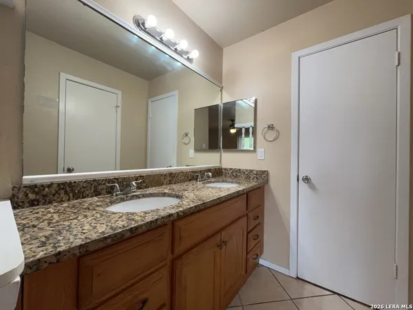 a bathroom with a granite countertop sink and a mirror
