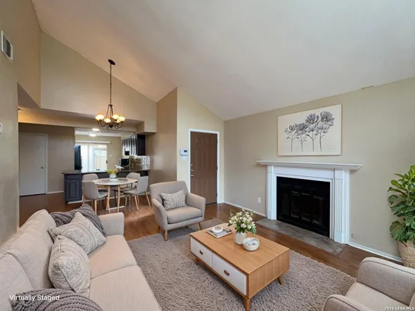a living room with furniture a fireplace and a chandelier