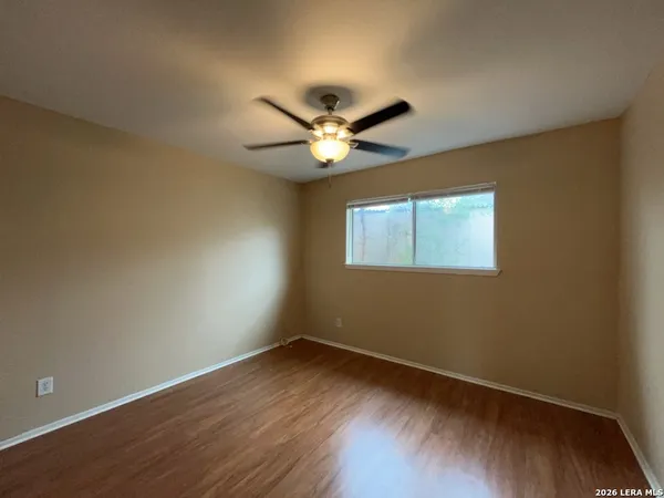 a view of a workspace with wooden floor and a ceiling fan