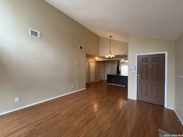 an empty room with wooden floor and cabinet