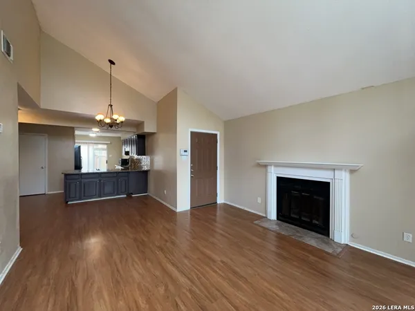 an empty room with wooden floor fireplace and cabinet