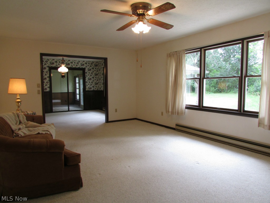 12044 Huntoon Road Painesville, OH 44077 - Photo 4 of 25 The living room windows open to vistas of the yard, fields and woodland beyond.