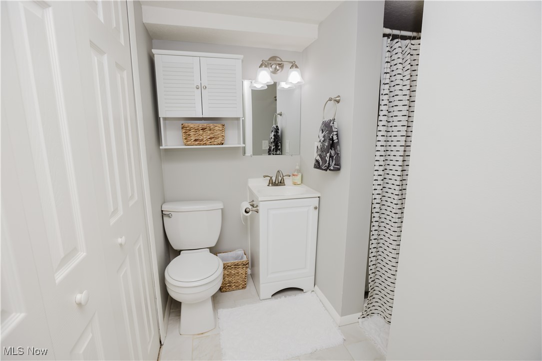 16940 Howe Road Strongsville, OH 44136 - Photo 12 of 33 Full bathroom featuring vanity, light tile patterned floors, a closet, and a shower with curtain