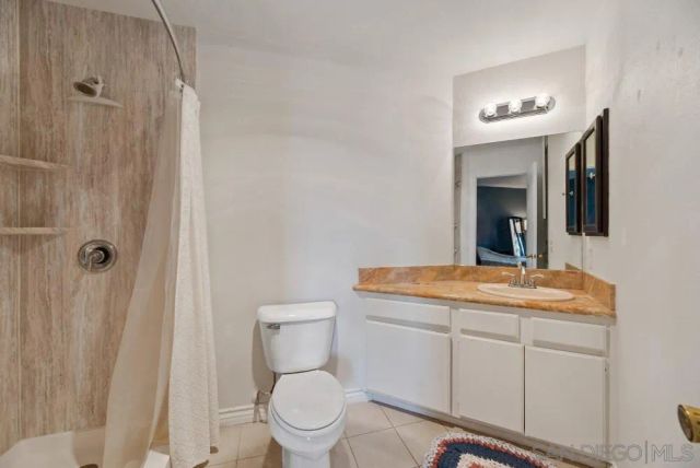 a bathroom with a toilet a sink a vanity and mirror