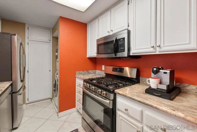 a kitchen with stainless steel appliances granite countertop a stove a microwave and a refrigerator