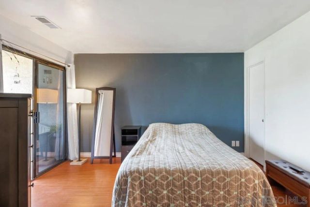 a bedroom with a bed and a refrigerator