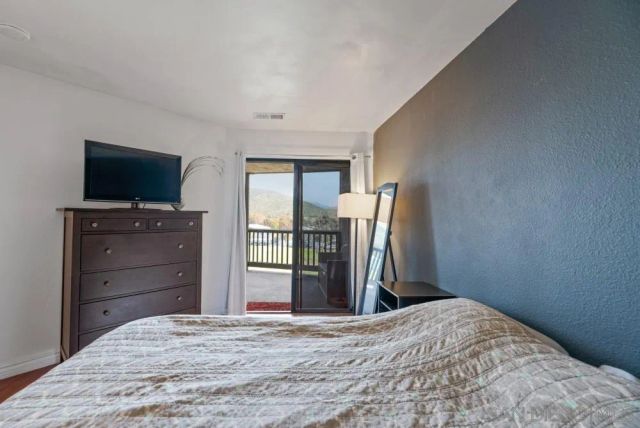 a bedroom with a bed and a flat screen tv