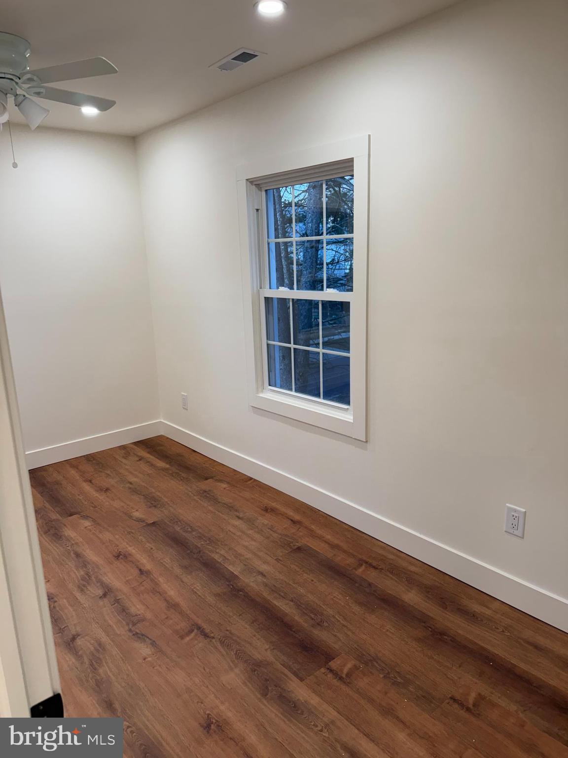 202 Chestnut Street Brooklawn, NJ 08030 - Photo 18 of 29 an empty room with wooden floor and windows