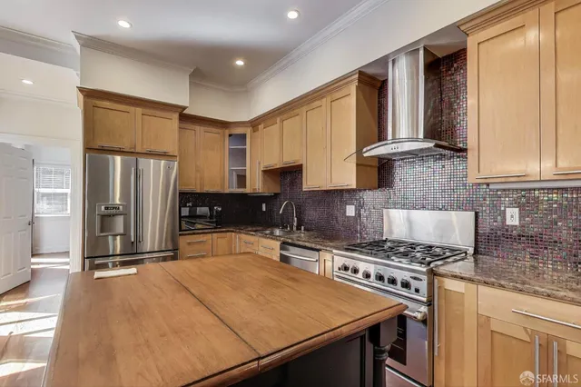 a kitchen with stainless steel appliances granite countertop a stove refrigerator sink and cabinets