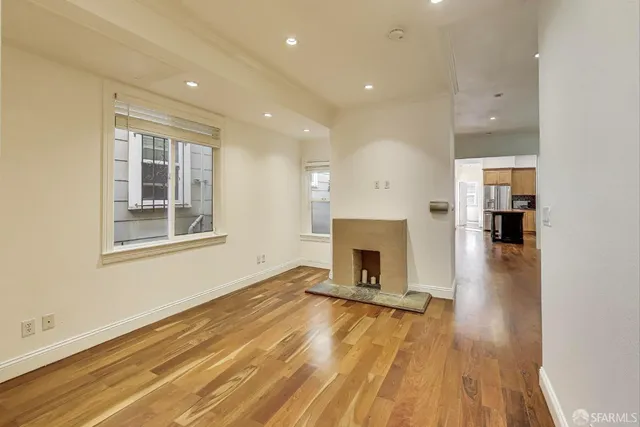 a view of empty room with a fireplace and wooden floor