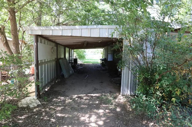 a view of a house with a yard and large tree