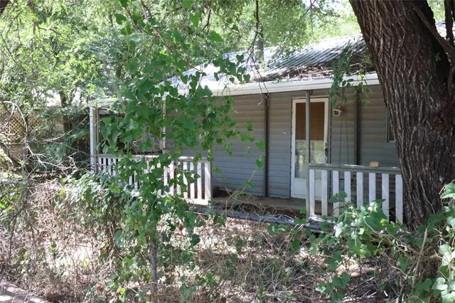 a view of a house with a small yard and wooden fence