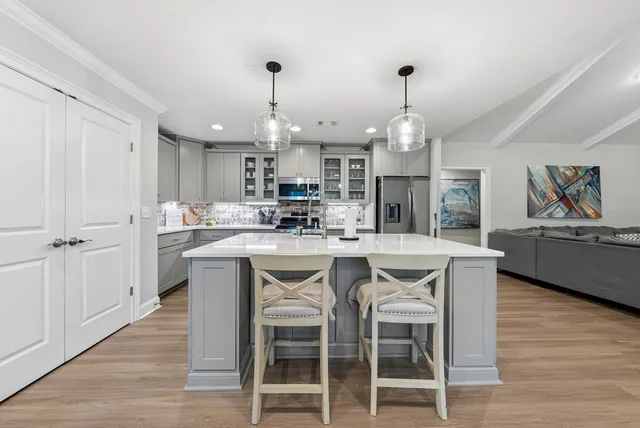 a kitchen with a sink a counter top space appliances and a center island