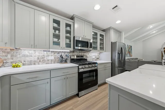 a kitchen with a refrigerator a stove and a wooden floor