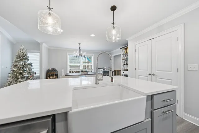 a kitchen with stainless steel appliances a sink dishwasher a refrigerator a stove top oven a oven with wooden floor