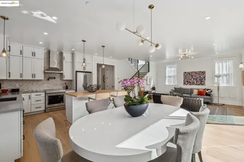 a view of a dining room and livingroom with furniture wooden floor a chandelier