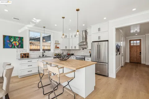 a kitchen with stainless steel appliances kitchen island granite countertop a refrigerator and a stove top oven