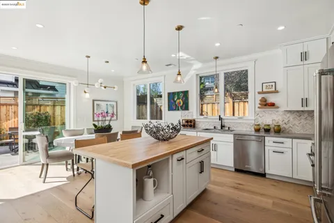 a kitchen with stainless steel appliances granite countertop a stove and a wooden floors