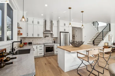 a kitchen with stainless steel appliances kitchen island granite countertop a stove a sink and a refrigerator