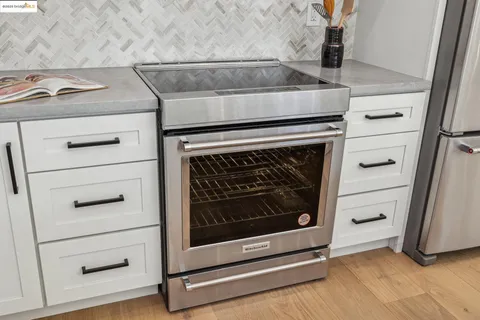 a stove top oven sitting inside of a kitchen