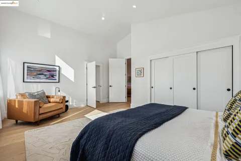 a bedroom with a bed couch and painting on the wall