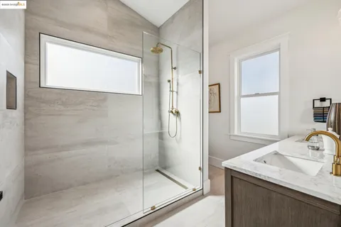 a bathroom with a granite countertop sink mirror and shower