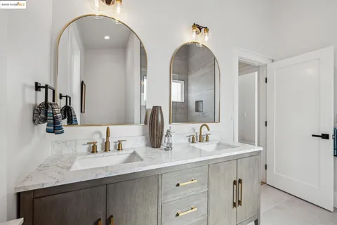 a bathroom with double vanity sinks and a mirror