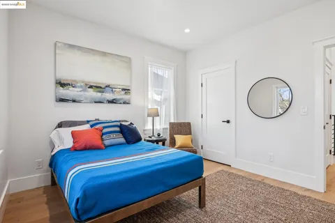 a bedroom with a bed a mirror and a lamp on dresser