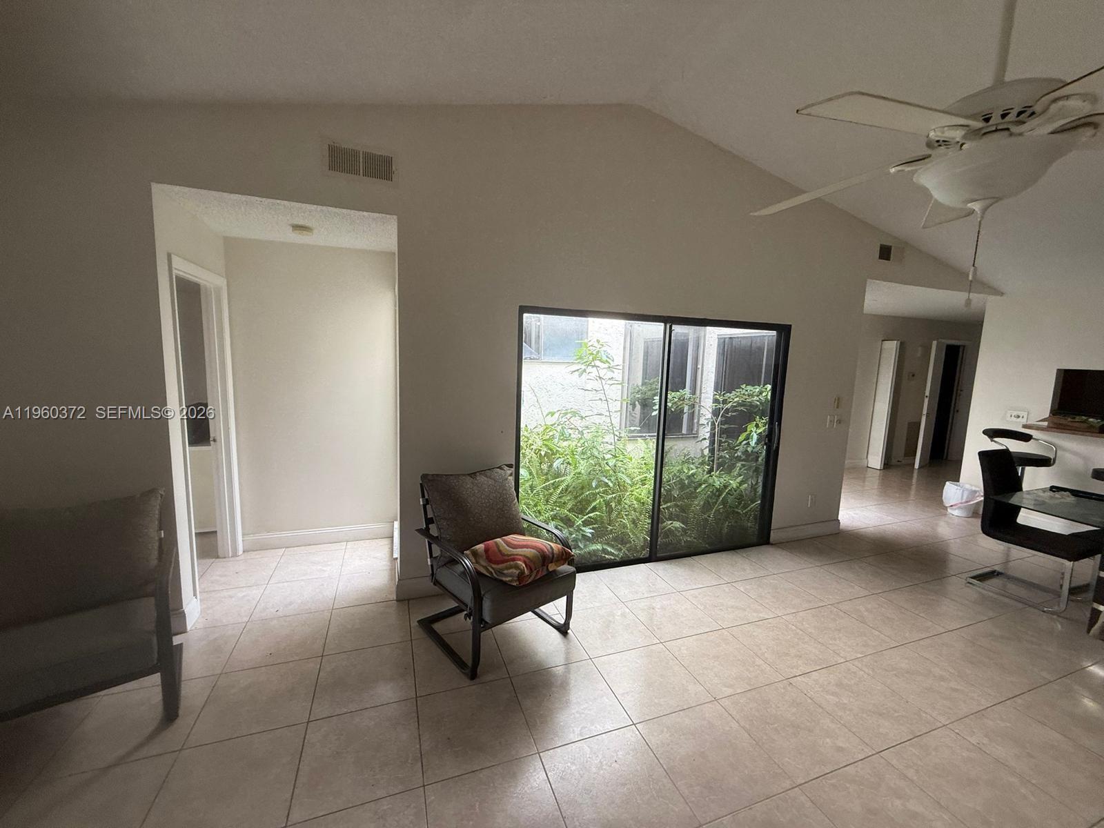 5223 Gate Lake Road, Unit 5223 Tamarac, FL 33319 - Photo 3 of 12 a living room with furniture and a floor to ceiling window
