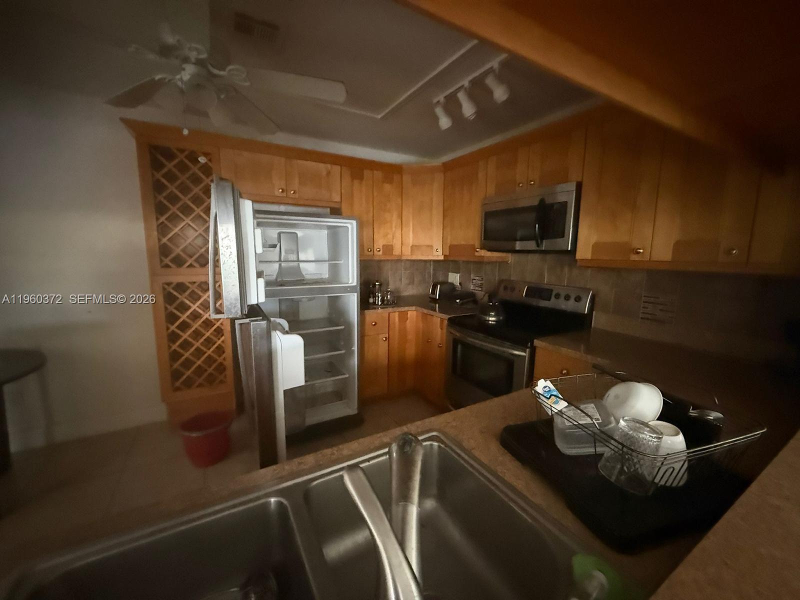 5223 Gate Lake Road, Unit 5223 Tamarac, FL 33319 - Photo 5 of 12 a kitchen with a sink appliances and cabinets