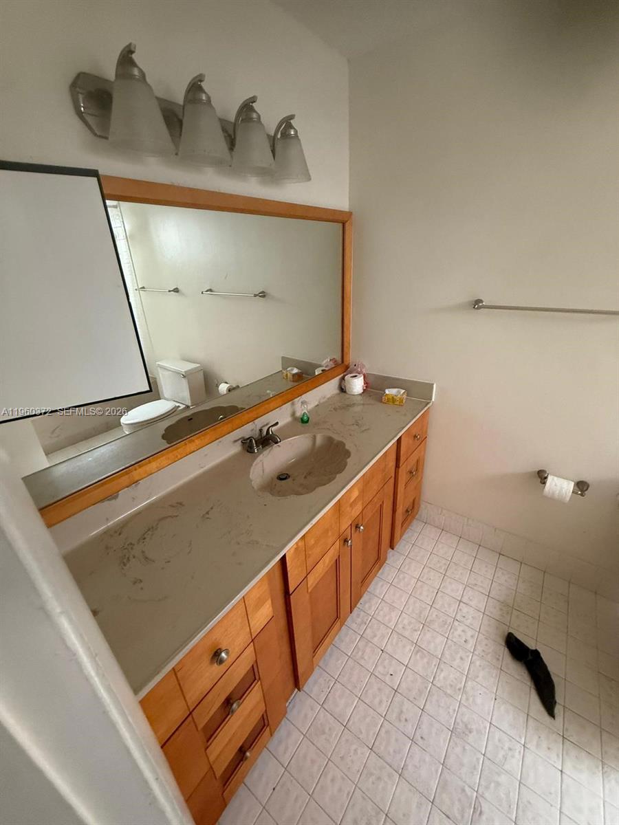 5223 Gate Lake Road, Unit 5223 Tamarac, FL 33319 - Photo 7 of 12 a spacious bathroom with a granite countertop sink and a mirror