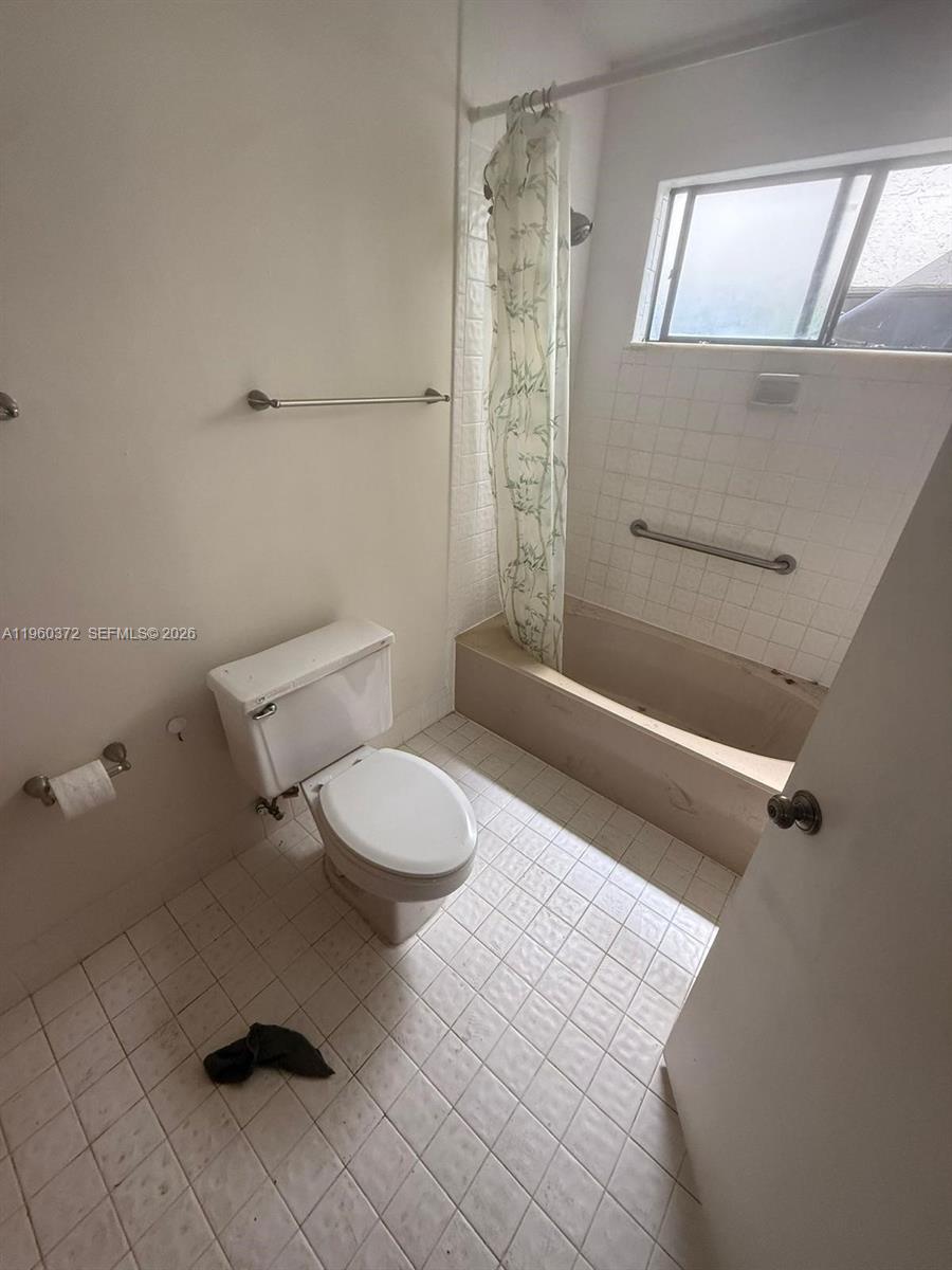 5223 Gate Lake Road, Unit 5223 Tamarac, FL 33319 - Photo 8 of 12 a bathroom with a toilet and a shower