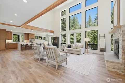 a living room with furniture large windows and a fireplace