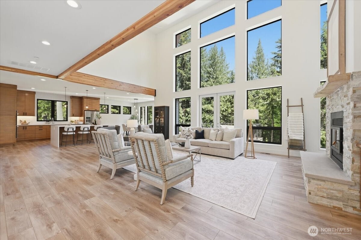 7416 Lake Alice Road Southeast Fall City, WA 98024 - Photo 4 of 40 a living room with furniture large windows and a fireplace