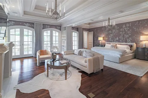 a spacious bedroom with a bed and a chandelier