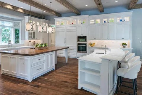 a kitchen with granite countertop a sink cabinets and wooden floor