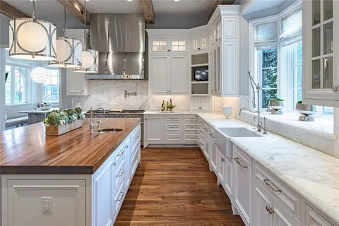 a large kitchen with stainless steel appliances granite countertop a lot of counter space and wooden floor