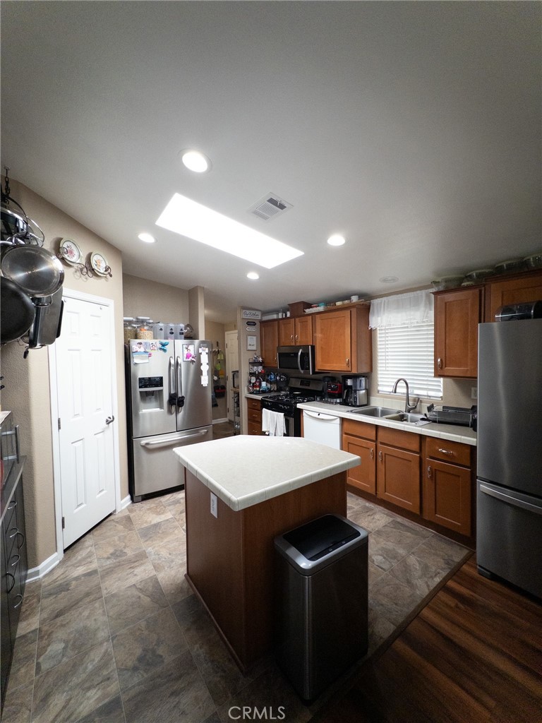 20843 Waalew Road Apple Valley, CA 92307 - Photo 21 of 32 a kitchen with stainless steel appliances kitchen island a sink stove and refrigerator