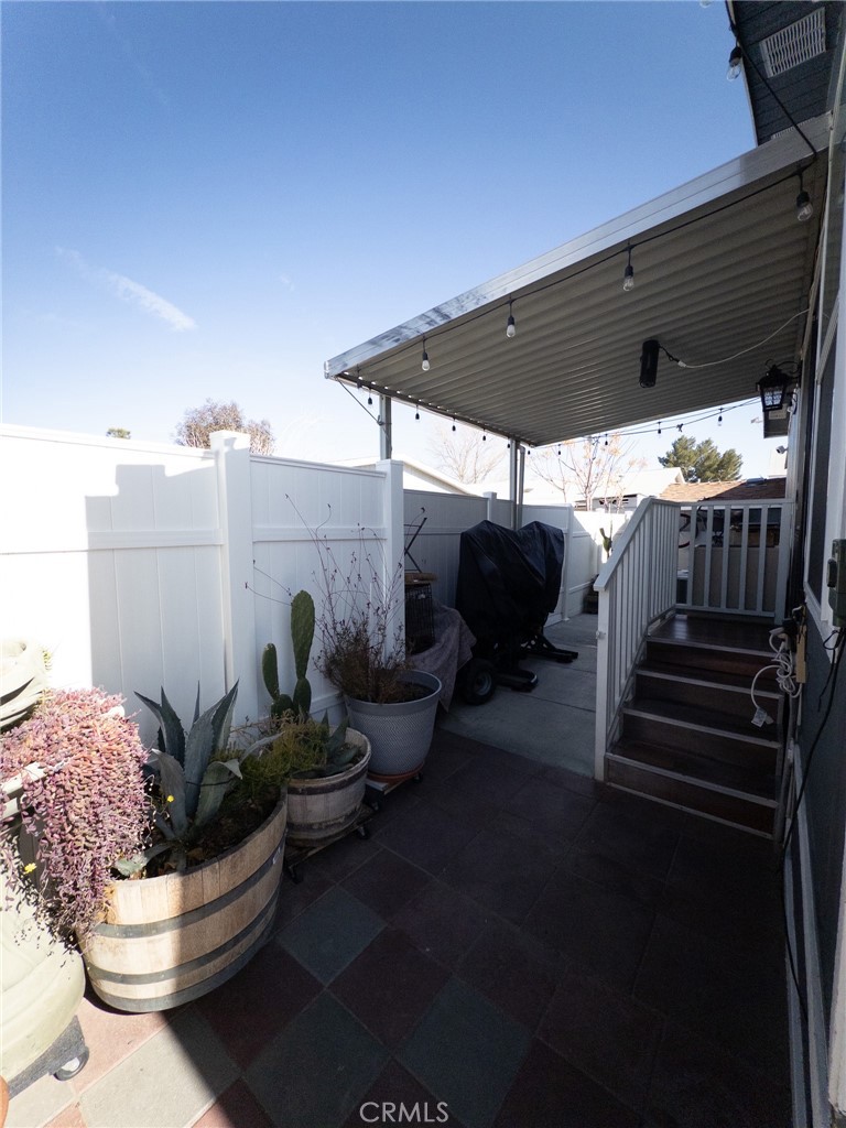 20843 Waalew Road Apple Valley, CA 92307 - Photo 8 of 32 a view of a patio with table and chairs potted plants with the wooden floor