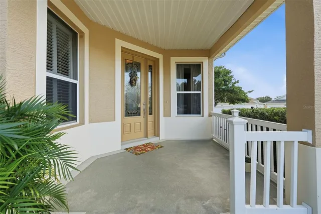 a view of a house with a floor to ceiling window and potted plants