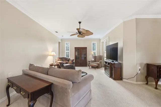 a living room with furniture a flat screen tv and a window