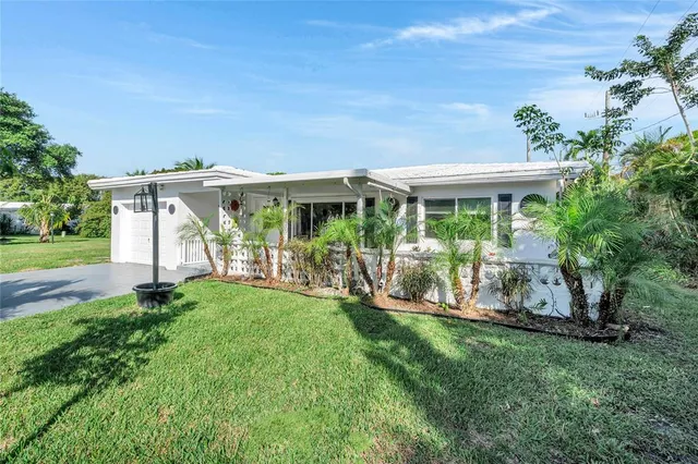 a view of a house with backyard sitting area and garden