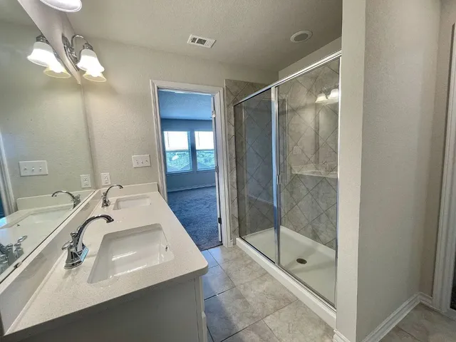 a bathroom with a shower sink and mirror