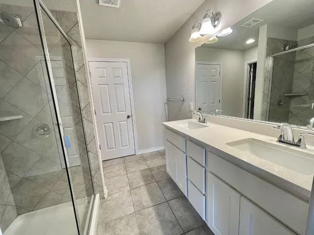 a bathroom with a double vanity sink and a mirror